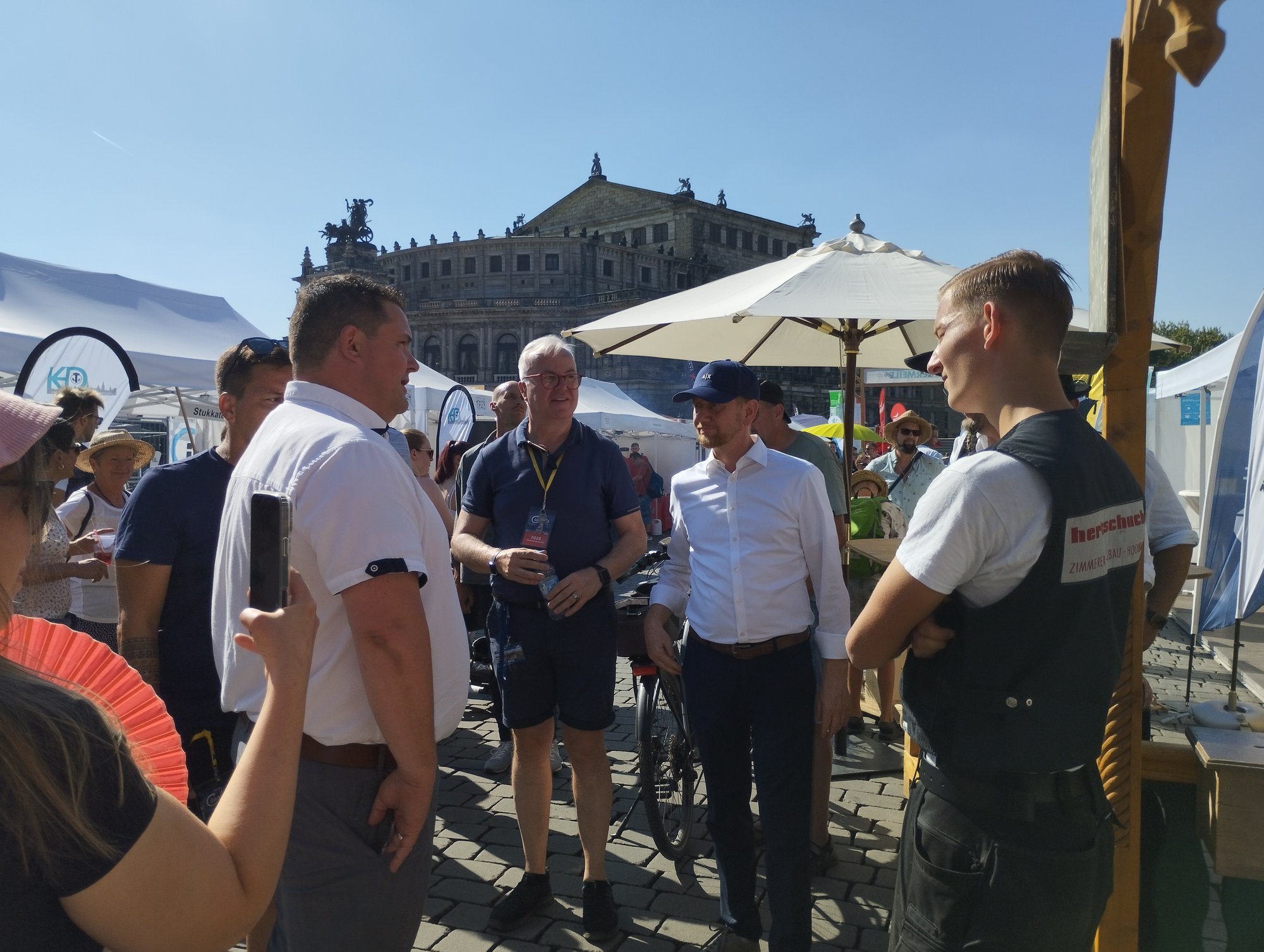 Gäste im Gespräch am Stand der Zimmererinnung Dresden auf der Handwerkermeile vor der Semperoper